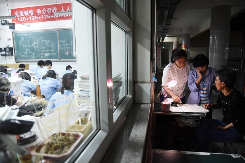 This May 23, 2018, photo shows a high school teacher answering questions ahead of the  college entrance examinations in China's northern Hebei province.